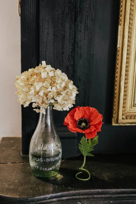 coquelicot en papier et hortensia séché sur un manteau de cheminée