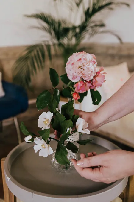 églantines en papier et roses fraîches sur une table basse
